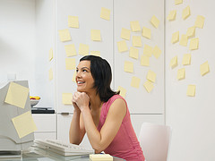 woman sitting in kitchen planning/dreaming with sticky notes all around